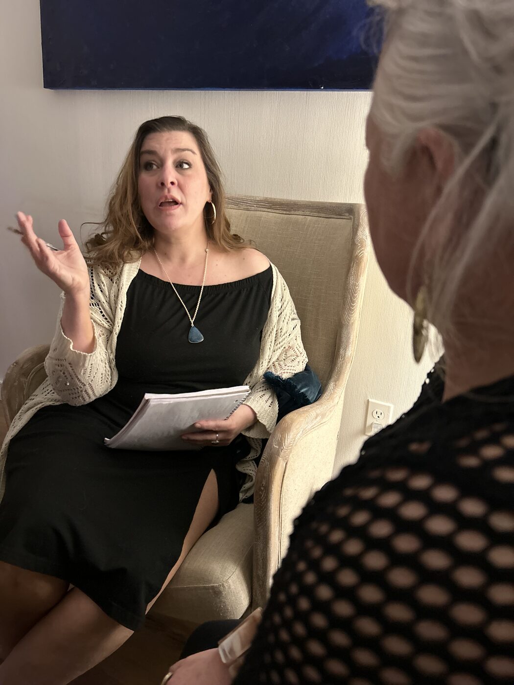Marisa McFadden facilitating a session, speaking and gesturing with notes in hand