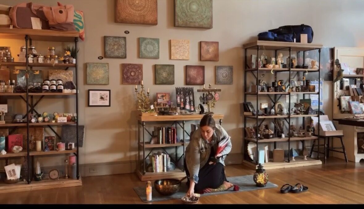 The front room of Creative Spirit with Marisa McFadden seated on the floor beside singing bowls